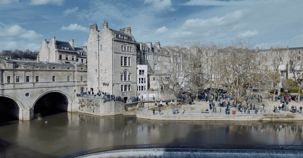 A view across the river Avon showing the Pulteney Bridge and the gardens below it